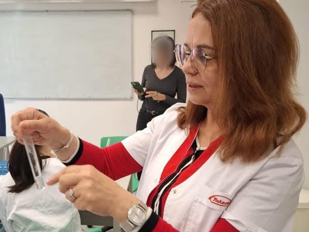Diana Argherie în laborator, ținând o eprubetă